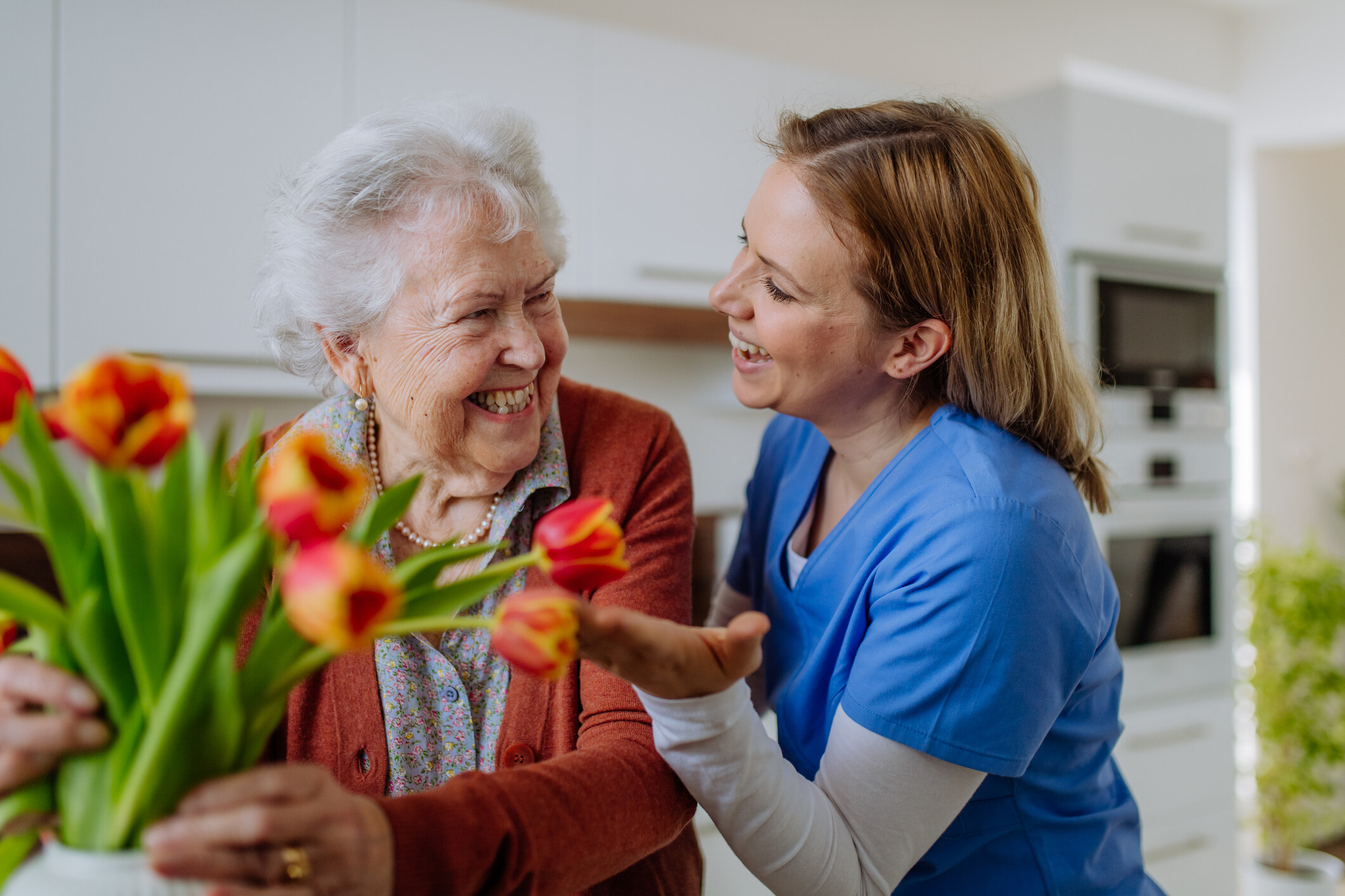 caregiver showing flowers to lady