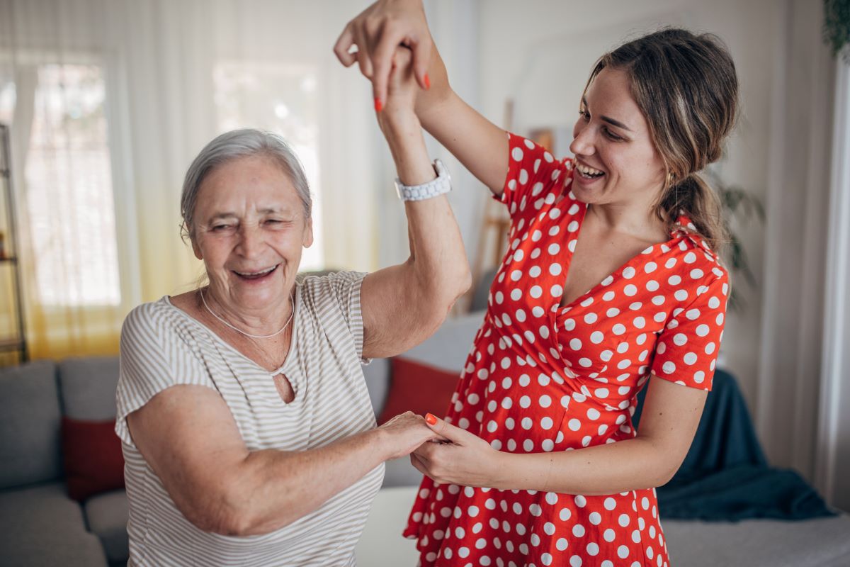 Grandmother and granddaughter smiling and dancing together