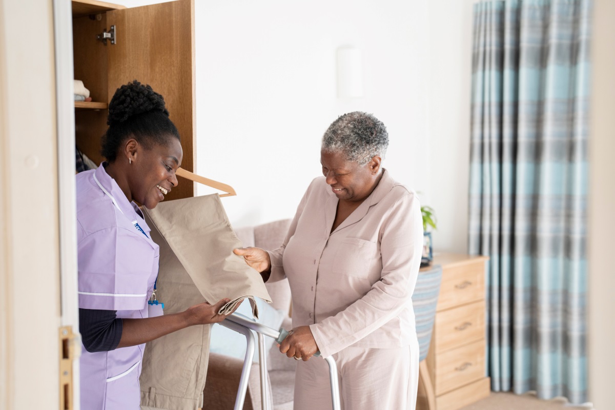 Caregiver helping older female adult select clothing