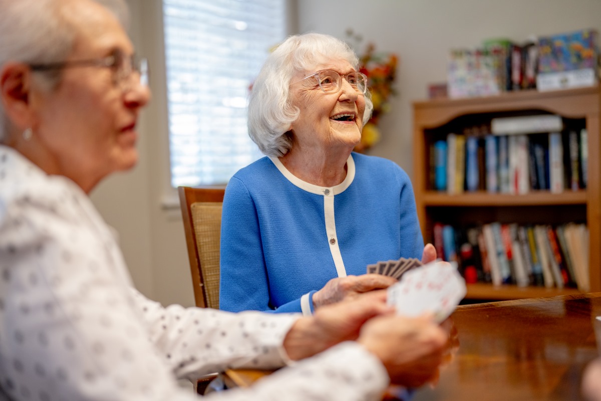 two older adult females playing cards