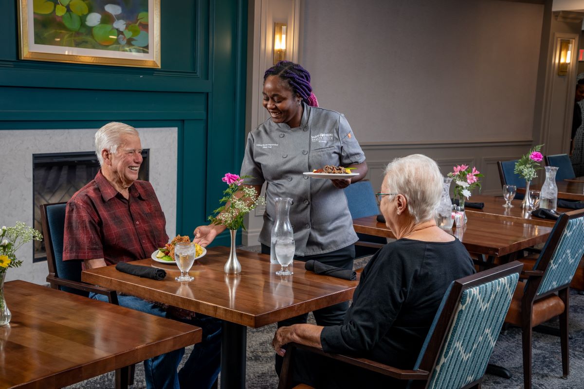 older couple speaking with server in dining room