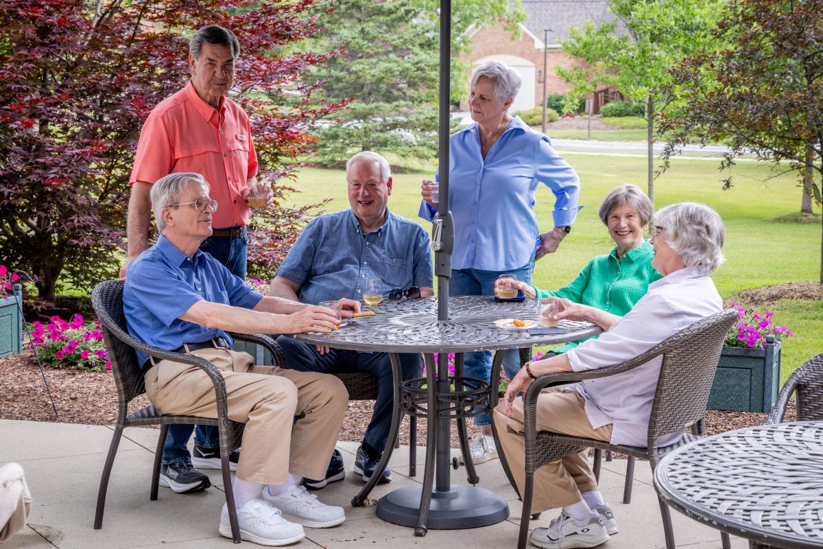group of older adults socializing with beverages outdoors on the patio at Glacier Hills
