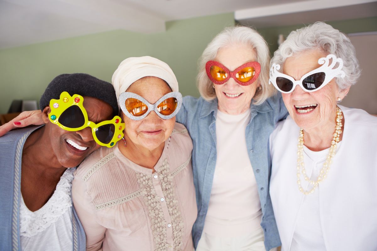 four older ladies wearing sunglasses having fun