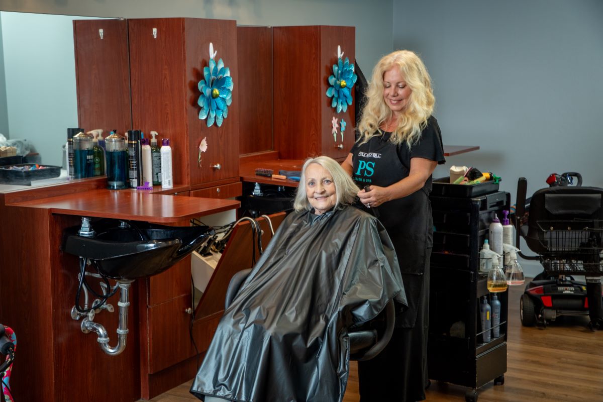 Assisted Living resident having her hair done by hairdresser