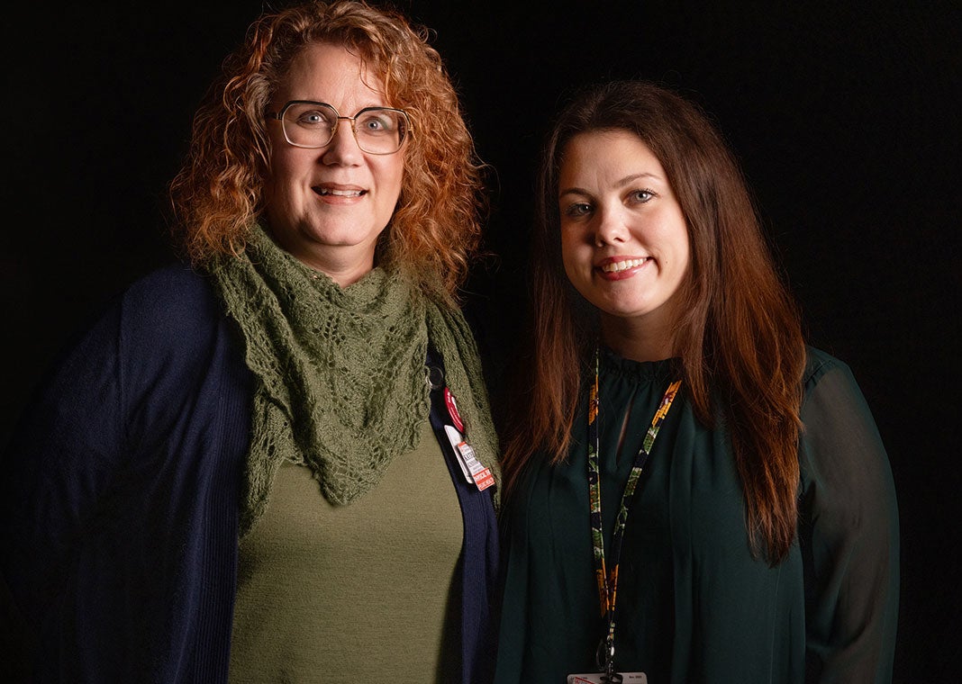 Two smiling physical therapists from St. Peter's Health Partners pose together against a dramatic black background.