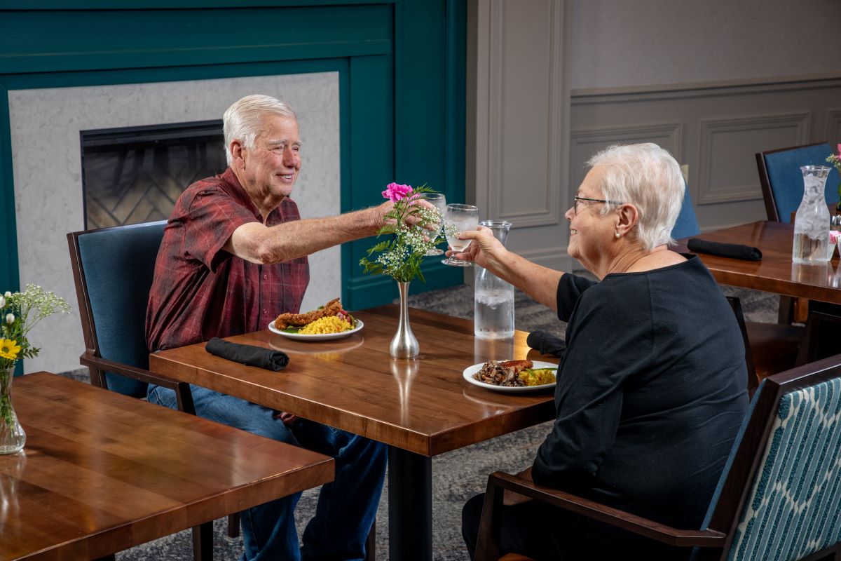 Senior couple toasting glasses and enjoying dinner at St. Paul's